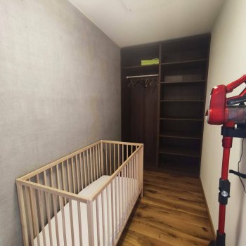 großer begehbarer Kleiderschrank mit Babybett